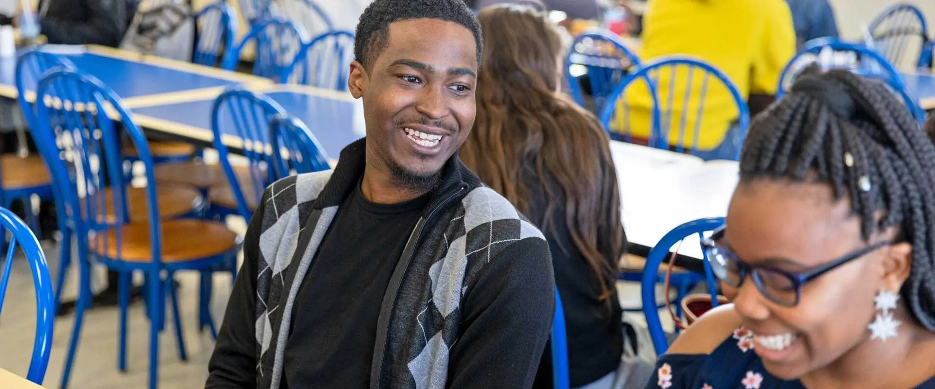 Students having a happy conversation in cafeteria