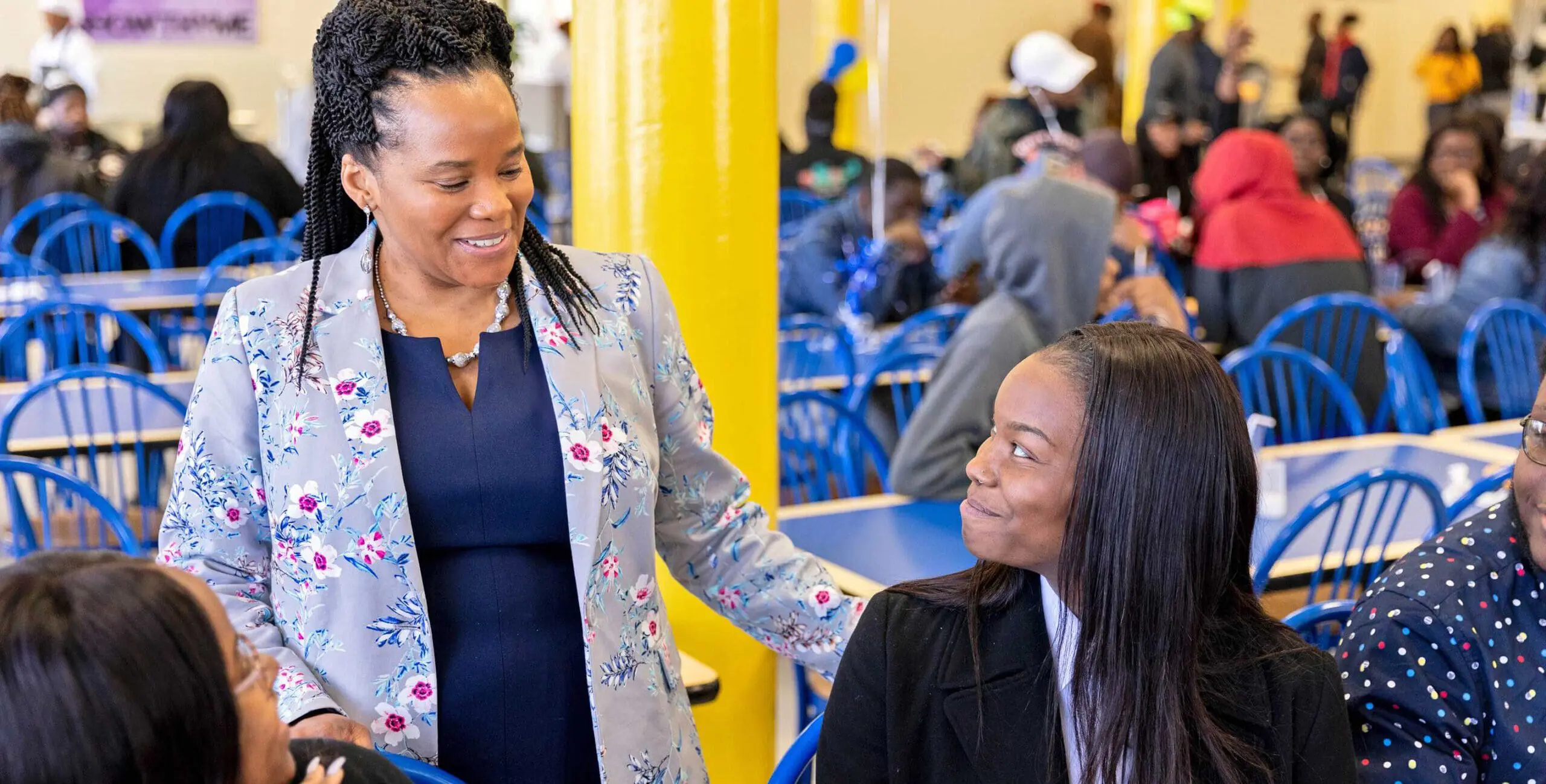 Manager speaking with students in cafeteria