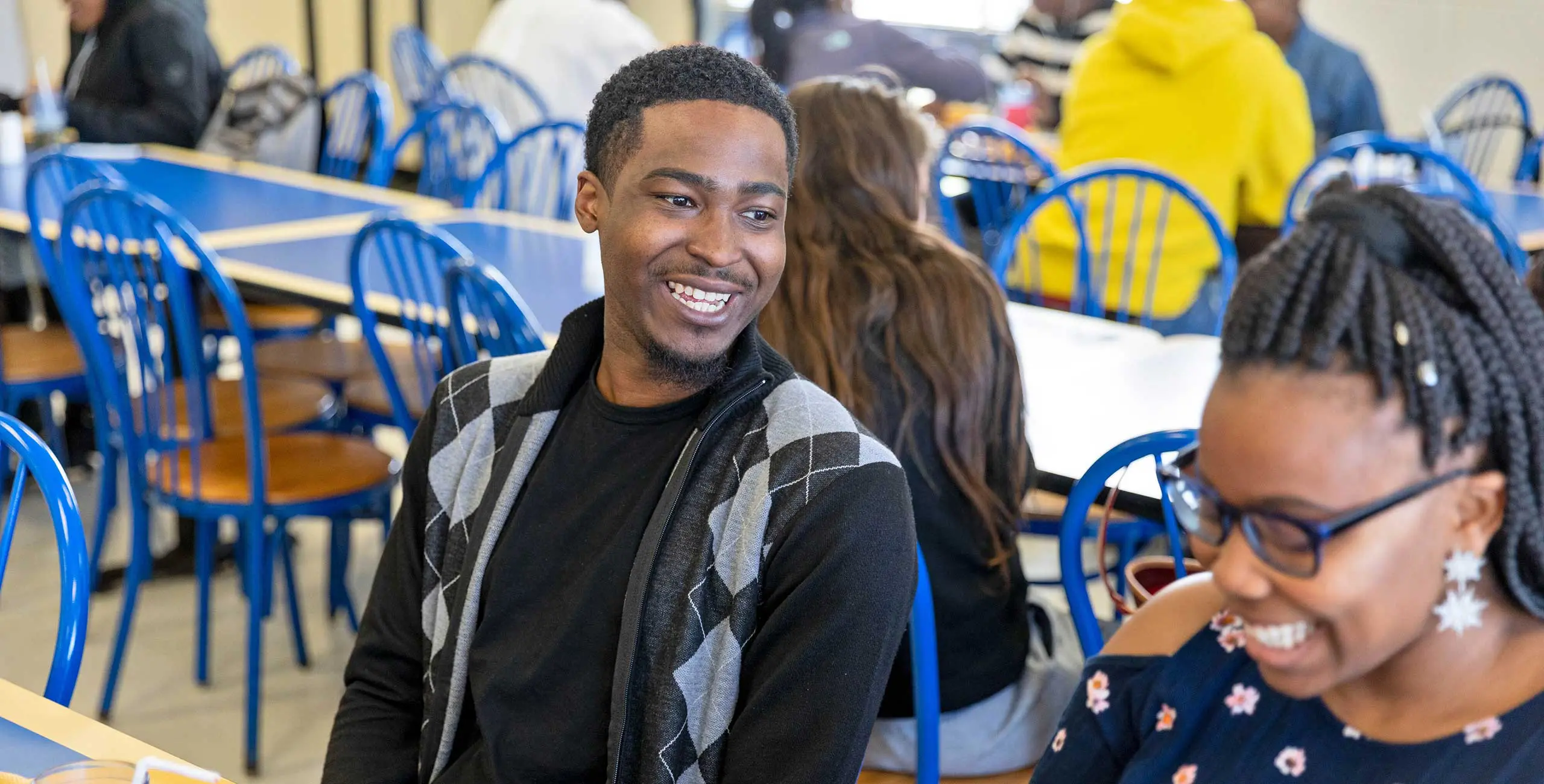 Students having a happy conversation in cafeteria
