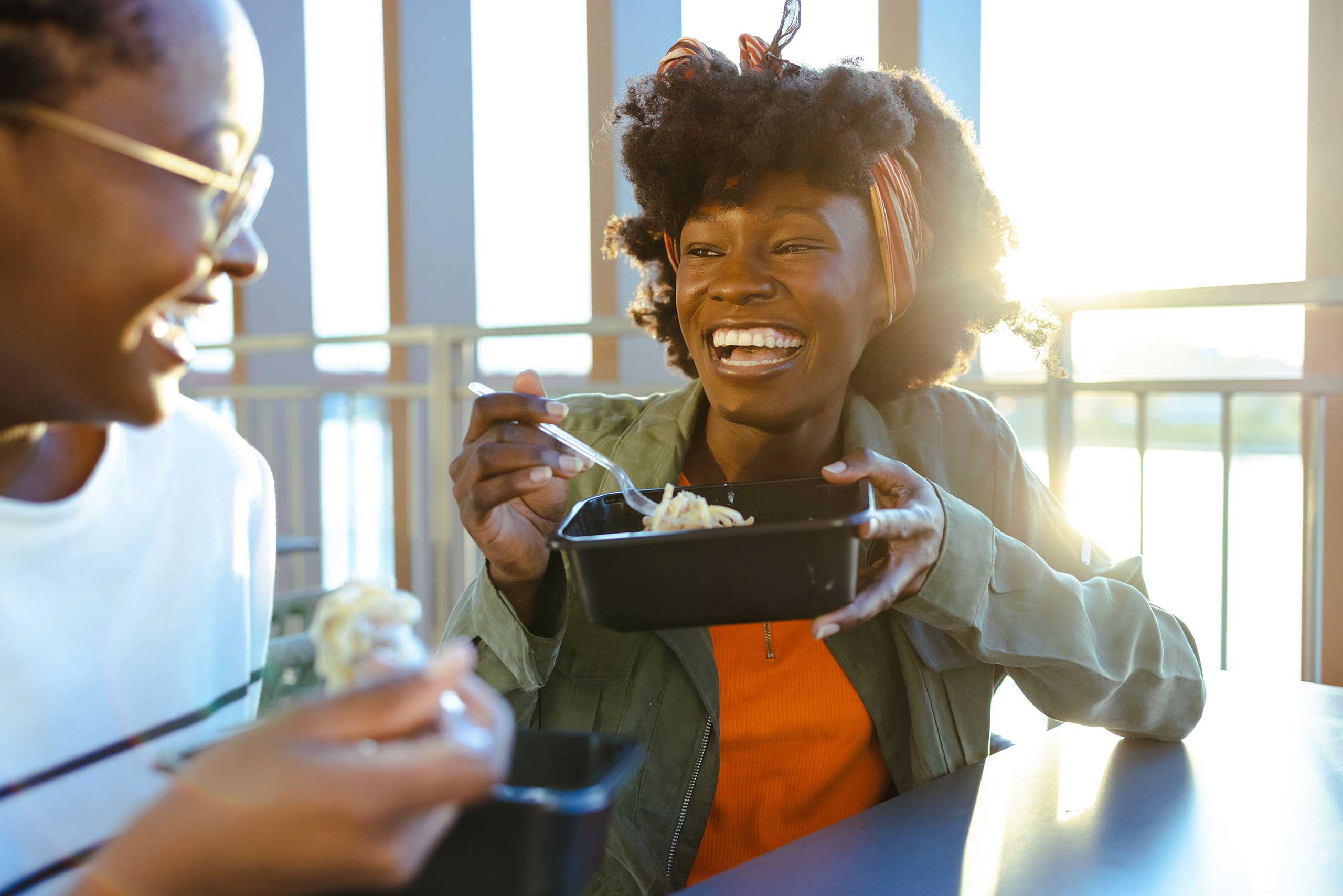 Two students sitting at table enjoying a snack