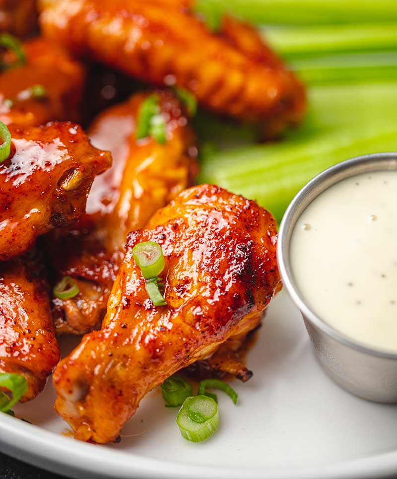Close up of buffalo chicken wings with celery and rach